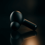 Cinematic product photo of a matte-black wireless earbud on a reflective surface, created with the best AI image generator tools.